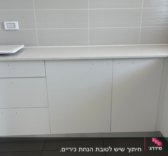 משטח שיש במטבח עם ארונות לבנים
